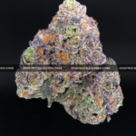 Close-up of Slapz strain showing dense olive green buds with blue undertones, amber hairs, and a frosty layer of blue-tinted trichomes, available for weed delivery in Virginia and Washington, DC. Known for its sweet lemon-lavender flavor and hard-hitting euphoric high.