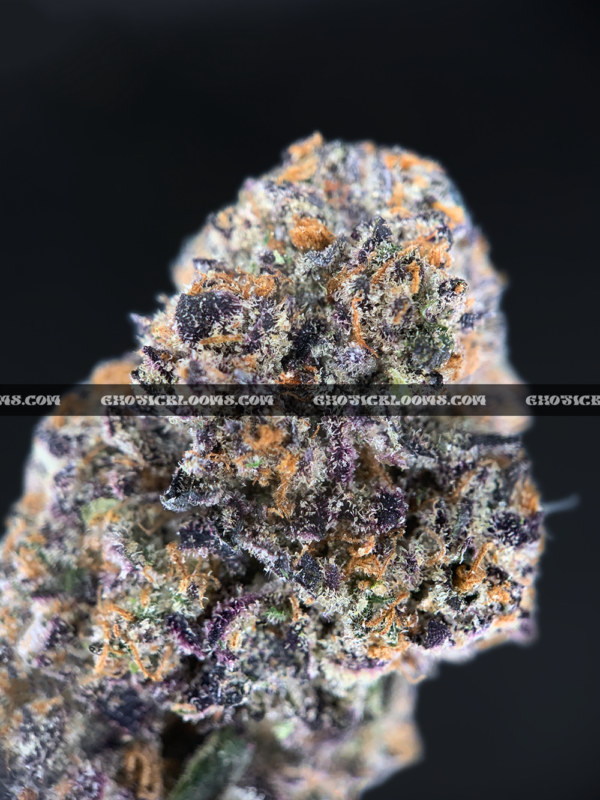 Close-up of Slapz strain showing dense olive green buds with blue undertones, amber hairs, and a frosty layer of blue-tinted trichomes, available for weed delivery in Virginia and Washington, DC. Known for its sweet lemon-lavender flavor and hard-hitting euphoric high.