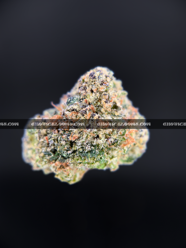 Close-up of Candy Glue strain featuring forest green grape-shaped buds with amber undertones, orange hairs, and frosty golden-white trichomes, available for weed delivery in Virginia and Washington, DC. Known for its sweet candy flavor and euphoric sativa-leaning effects.
