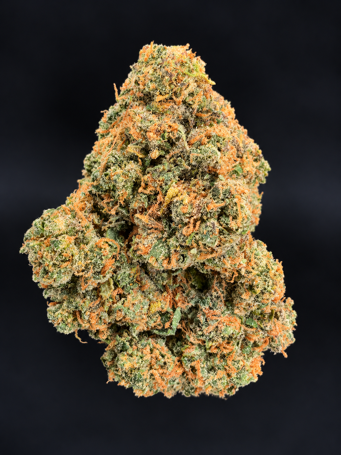 Macro photograph of Wizzy by Wizard Trees cannabis flower showing dense green buds, orange pistils, and frosty trichomes at Exotic Blooms in Washington DC.